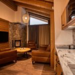 Kuchynka a obývacia časť v apartmáne DaSus Lux&Wellness Apartments Sosana s dreveným interiérom a pohodlným sedením.