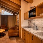 Interiér apartmánu DaSus Lux&Wellness Apartments Sosana s dreveným nábytkom, kuchynkou, koženým sedením a krbom.