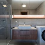 Moderná kúpeľňa s veľkým sprchovacím kútom, práčkou a dizajnovým umývadlom v apartmáne DaSus Luxury Tále.