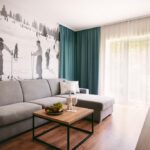Priestranná obývacia izba s pohodlnou sedačkou a vstupom na balkón v Apartmánoch Štiavnica & Ďurková
