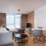 Priestranná obývacia izba s rozkladacou pohovkou a jedálenským kútom v apartmáne DaSus Luxury Tále.