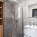 Moderná kúpeľňa so sprchovacím kútom, umývadlom a úložným priestorom v Apartmánoch Pálenica & Ostredok